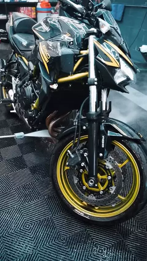 Moto noire et or au nettoyeur haute pression